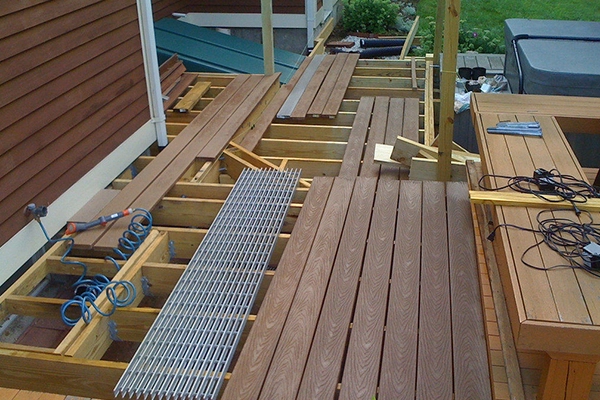 Residential deck under construction with wood planks and framework visible.